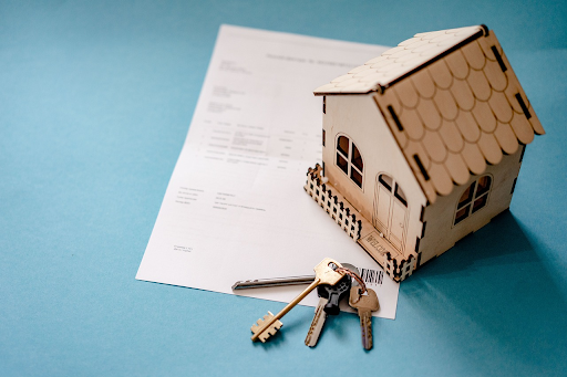 A small house with keys on top of a VA home loans document.