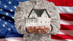 A veteran in uniform holding the home he bought with VA Mortgage type